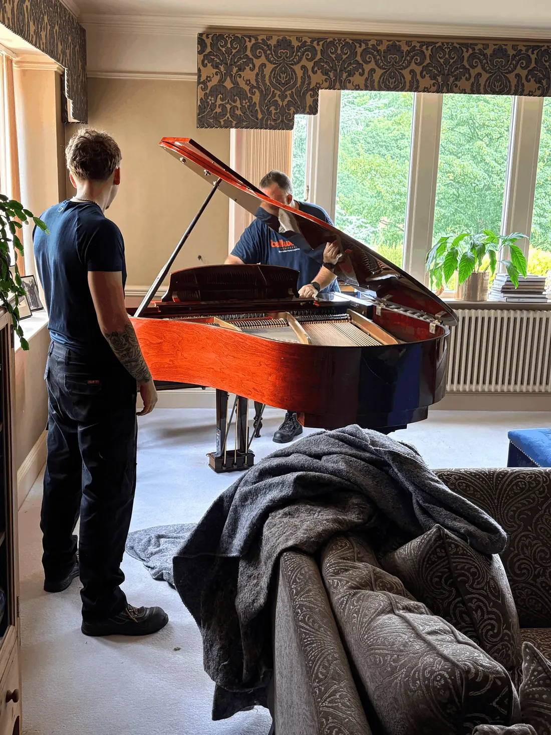 Grand piano being reassembled in a living room after a specialist move